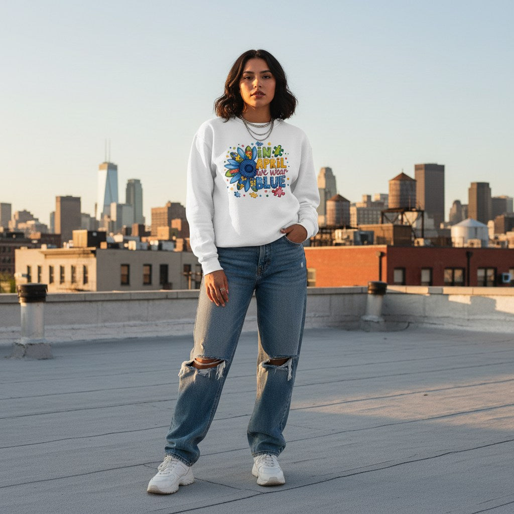 Latina woman wearing a white "In April We Wear Blue" autism sunflower sweatshirt.