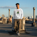 Latino man wearing a white "Be Happy In Your Own Shell" rainbow turtle sweatshirt.