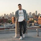 Latino man wearing a white autism awareness skeleton puzzle t-shirt.