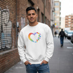 Latino man wearing a white rainbow heart puzzle sweatshirt.