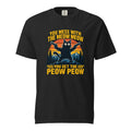 Front view of a black T-shirt featuring a cat holding two pistols before striped mountains and pine trees, with bold yellow text.