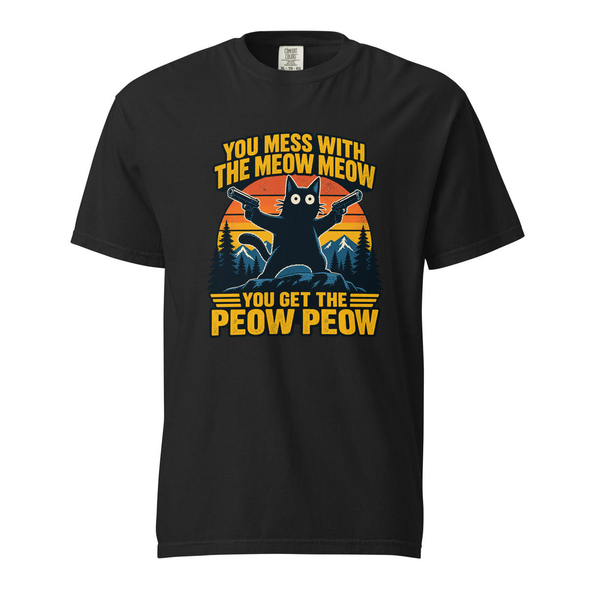 Front view of a black T-shirt featuring a cat holding two pistols before striped mountains and pine trees, with bold yellow text.