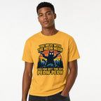 Model wearing a mustard T-shirt featuring a black cat holding two pistols before mountains, with bold yellow wording.