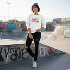Middle Eastern non-binary person wearing a white autism acceptance infinity sweatshirt.