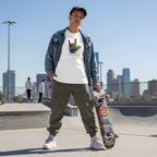 Middle Eastern non-binary person wearing a white be kind autism awareness t-shirt in a streetwear style.