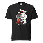 Front view of a black T-shirt featuring a horned white monster operating a red gumball machine filled with miniature skulls.