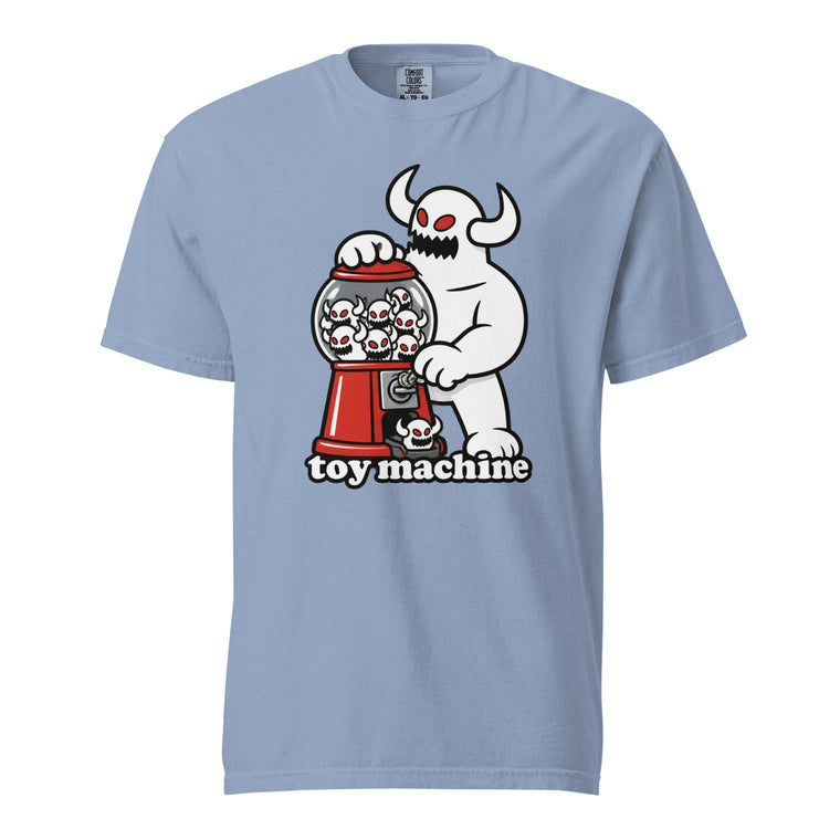 Front view of a Washed Denim T-shirt featuring a horned white monster operating a red gumball machine filled with miniature skulls.