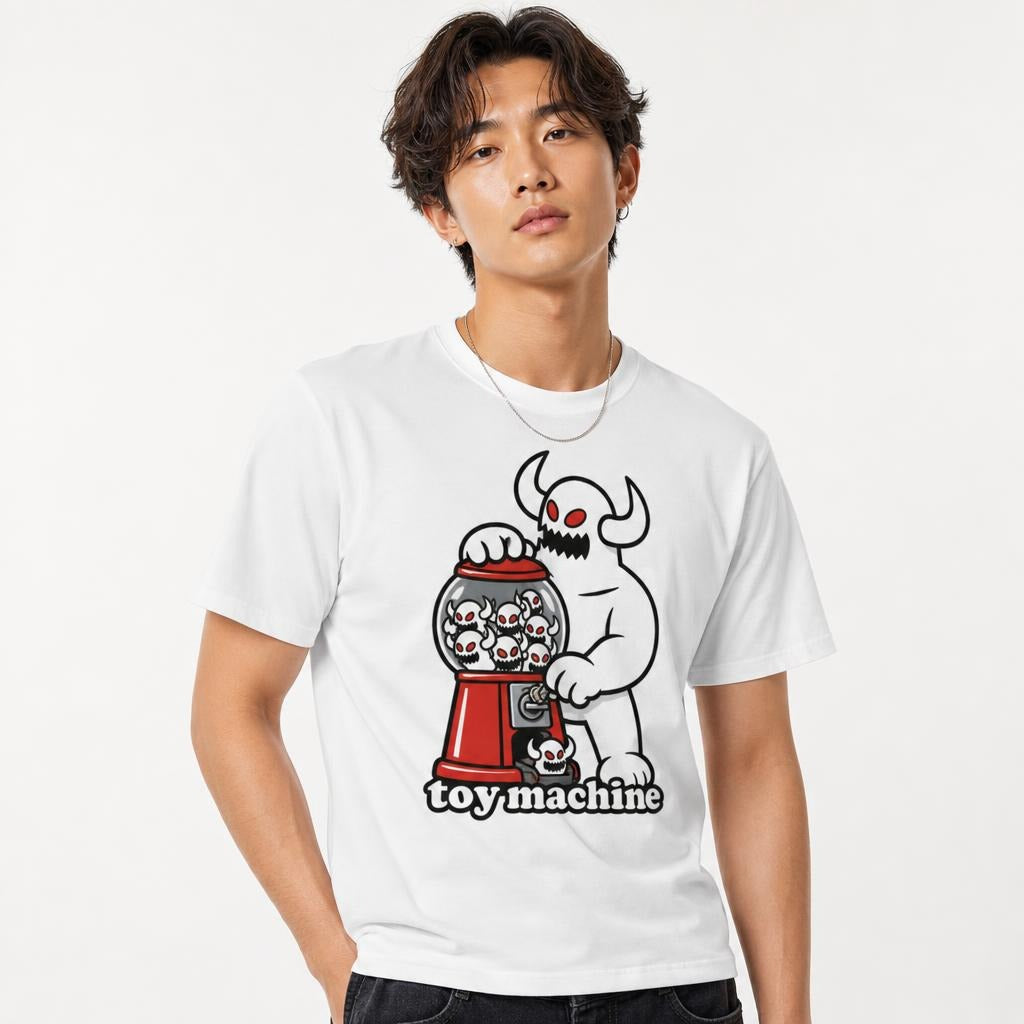 Model wearing a White T-Shirt featuring a horned monster with red eyes operating a red skull-filled gumball machine with “toy machine” text.