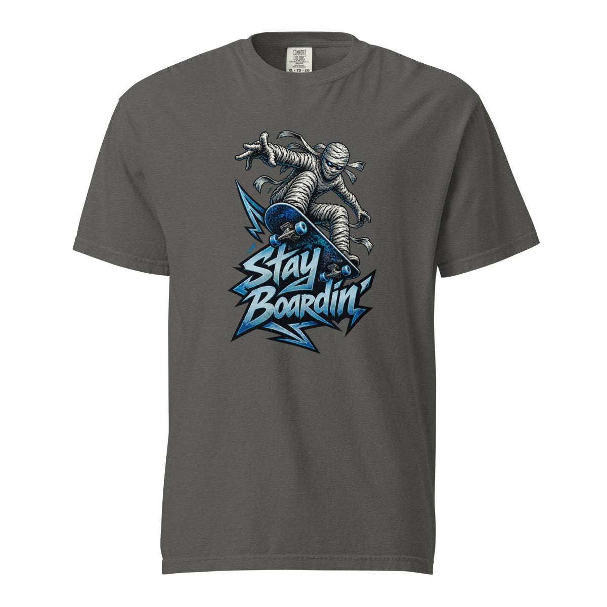 Front of a Pepper T-shirt featuring a bandage-wrapped mummy riding a blue skateboard above bold “STAY BOARDIN’” lettering.