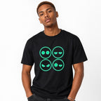 Model wearing a black T-shirt with four outlined neon-green emoji faces in a two-by-two grid, showing varied expressions.