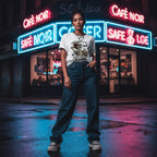 Model wearing a white t-shirt in a neon-lit street at night with dramatic lighting and reflections.