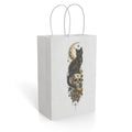 White paper gift bag with a gothic black cat, crescent moon, skull, stars, and Trick or Treat lettering
