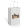 Front view of a white paper gift bag featuring an ornate Halloween Trick or Treat design with leaves, stars, and seasonal details.