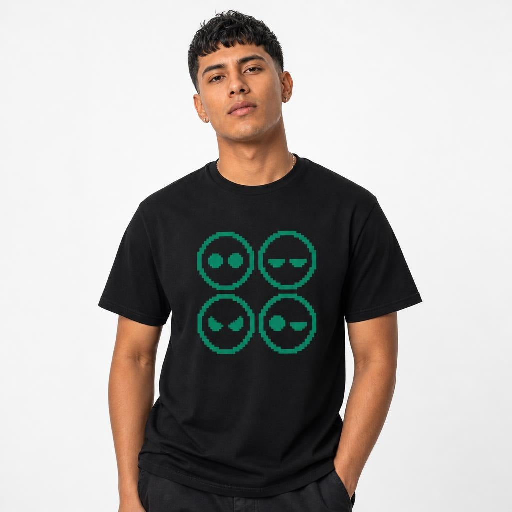 Model wearing a black T-shirt with a four-panel pixel-art graphic of four alien faces with varied expressions in green.