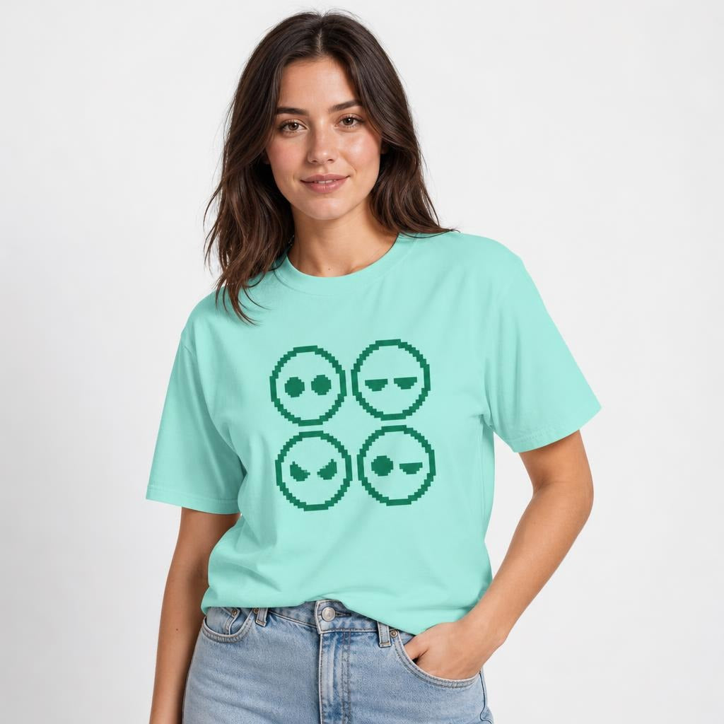 Front view of a model wearing a Chalky Mint T-shirt with a four-panel pixel-art graphic of four alien faces with varied expressions.