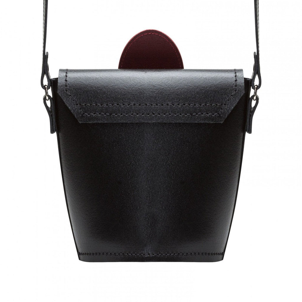 Black leather handbag with a strap on a white background
