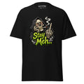 Black T-shirt featuring a skeletal character smoking a cigar beside the bright green words “Stay Meh...”