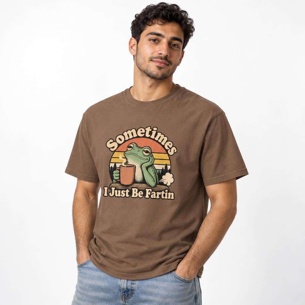 Front view of an Espresso T-shirt on a model, featuring a green frog holding a steaming coffee cup and the words “Sometimes I Just Be Fartin.”