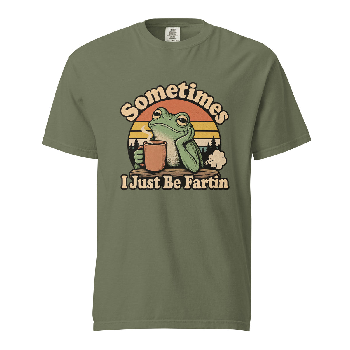 Front view of a moss T-shirt with “Sometimes I Just Be Fartin” lettering, a green frog holding a steaming coffee cup, and a sunset scene.