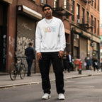 South Asian man wearing a white autism periodic table sweatshirt.
