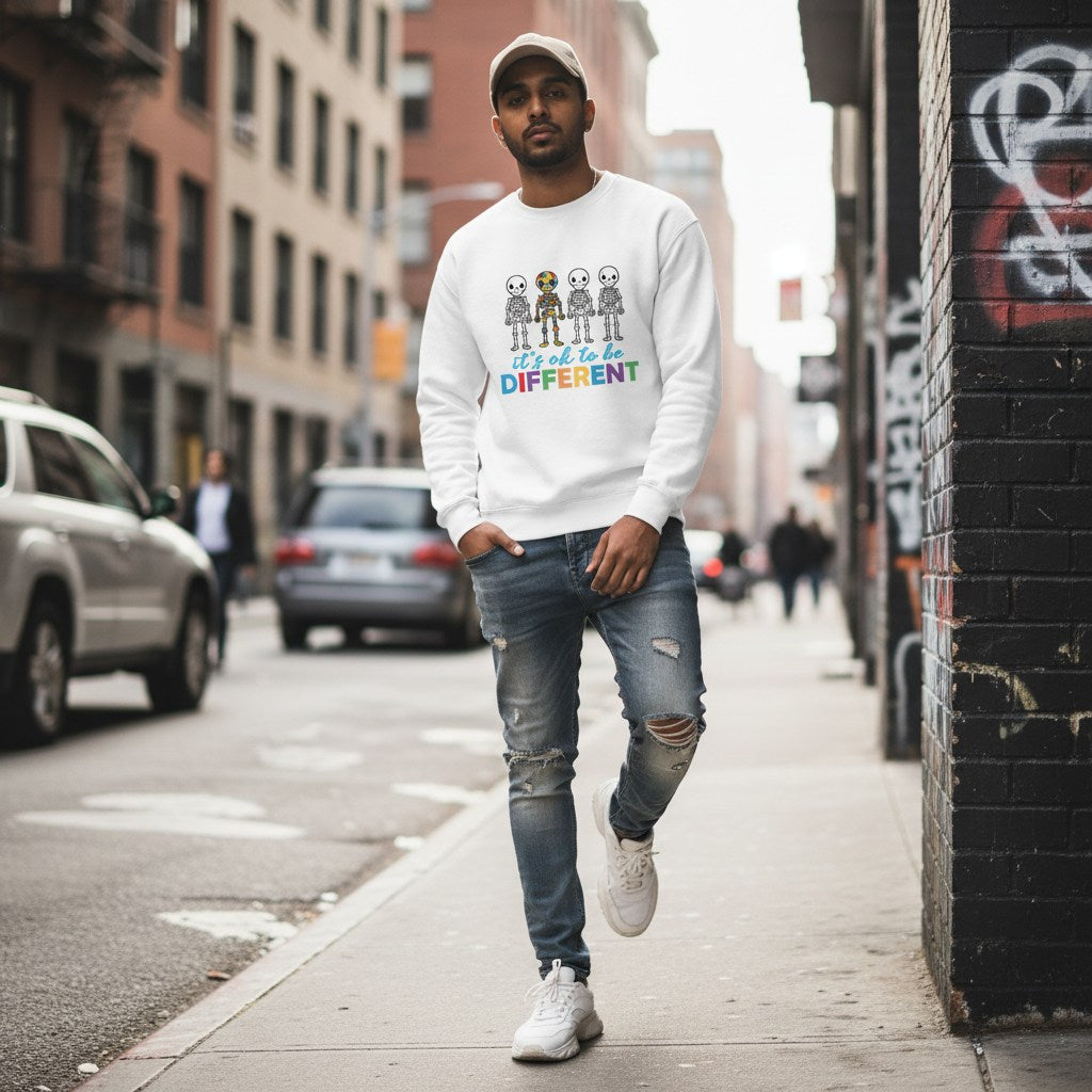 South Asian man wearing a white autism skeleton puzzle sweatshirt.