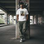 South Asian man wearing a white t-shirt and posing in an urban streetwear setting.