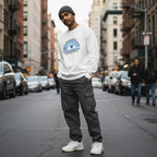 South Asian man wearing a white autism awareness sweatshirt.