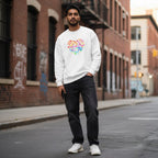 South Asian man wearing a white celebrate minds floral heart sweatshirt.