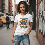 South Asian woman wearing a white autism awareness t-shirt in a streetwear style.