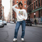 South Asian woman wearing a white autism mama collage sweatshirt.