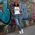 South Asian woman wearing a white Autism Mama collegiate T-shirt.