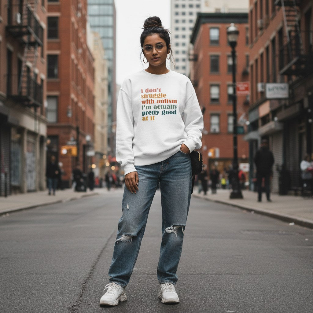 South Asian woman wearing a white "I Don't Struggle With Autism" sweatshirt.