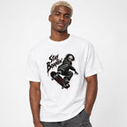 Model wearing a white T-shirt with “STAY BOARDIN’” lettering, a masked skateboarder, and a red target graphic on the skateboard.