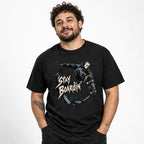 Model wearing a black T-shirt with a masked skateboarder airborne above a skateboard and jagged “STAY BOARDIN” lettering.