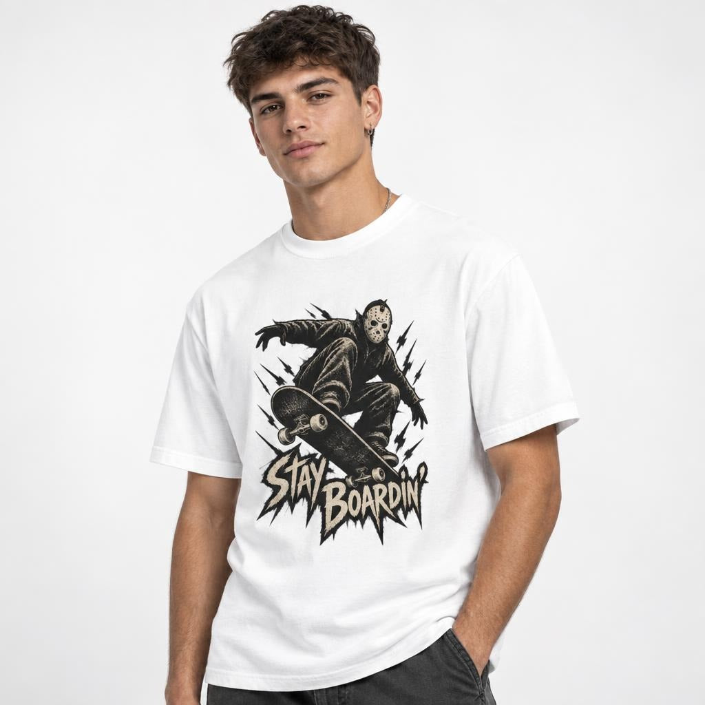 White T-shirt featuring a masked skater crouching on a skateboard above distressed “STAY BOARDIN’” lettering.