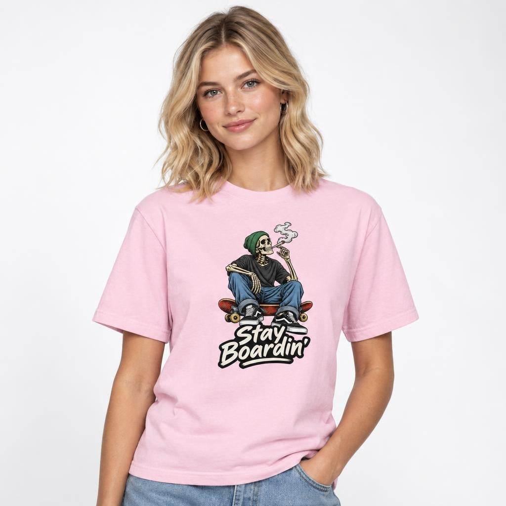 Front view of a Blossom T-shirt with a seated skeleton in a green beanie smoking on a skateboard above “Stay Boardin’” lettering.