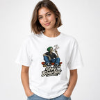 Front view of a person wearing a White T-shirt with a smoking skeleton seated on a skateboard above “Stay Boardin’” lettering.