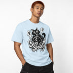 Front view of a model wearing the Chambray Stay Spooky T-shirt with a black cat behind a crystal ball, three ghosts, stars, and a crescent moon.