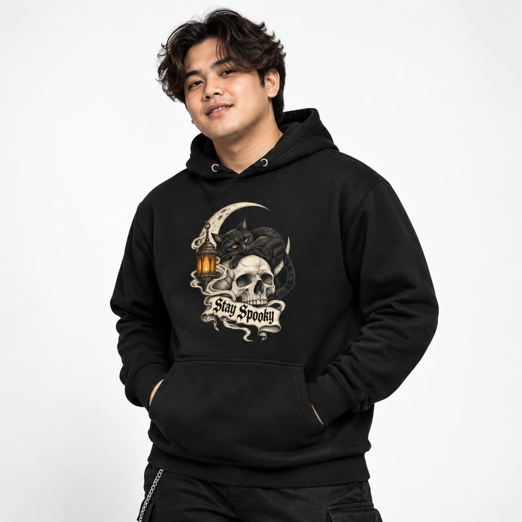Black hoodie featuring a black cat with amber eyes over a skull, framed by a crescent moon and lantern, with “Stay Spooky” text.