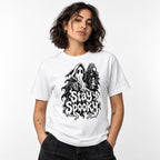 Model wearing a white T-shirt with a hooded ghost, lantern, skeletal hands, and dripping “Stay Spooky” graphic.