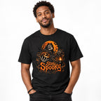 Front view of a black T-shirt featuring a Grim Reaper, glowing Pumpkin Lantern, orange moon, bats, and “Stay Spooky” lettering.