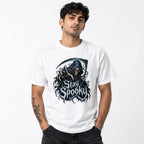 Front view of a model wearing a White T-shirt with a Grim Reaper, Skeleton and Scythe beneath distressed Stay Spooky lettering.