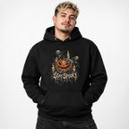 Model wearing a black hoodie with a grinning jack-o'-lantern, ghosts, skeletons, candles, and distressed “STAY SPOOKY” lettering.