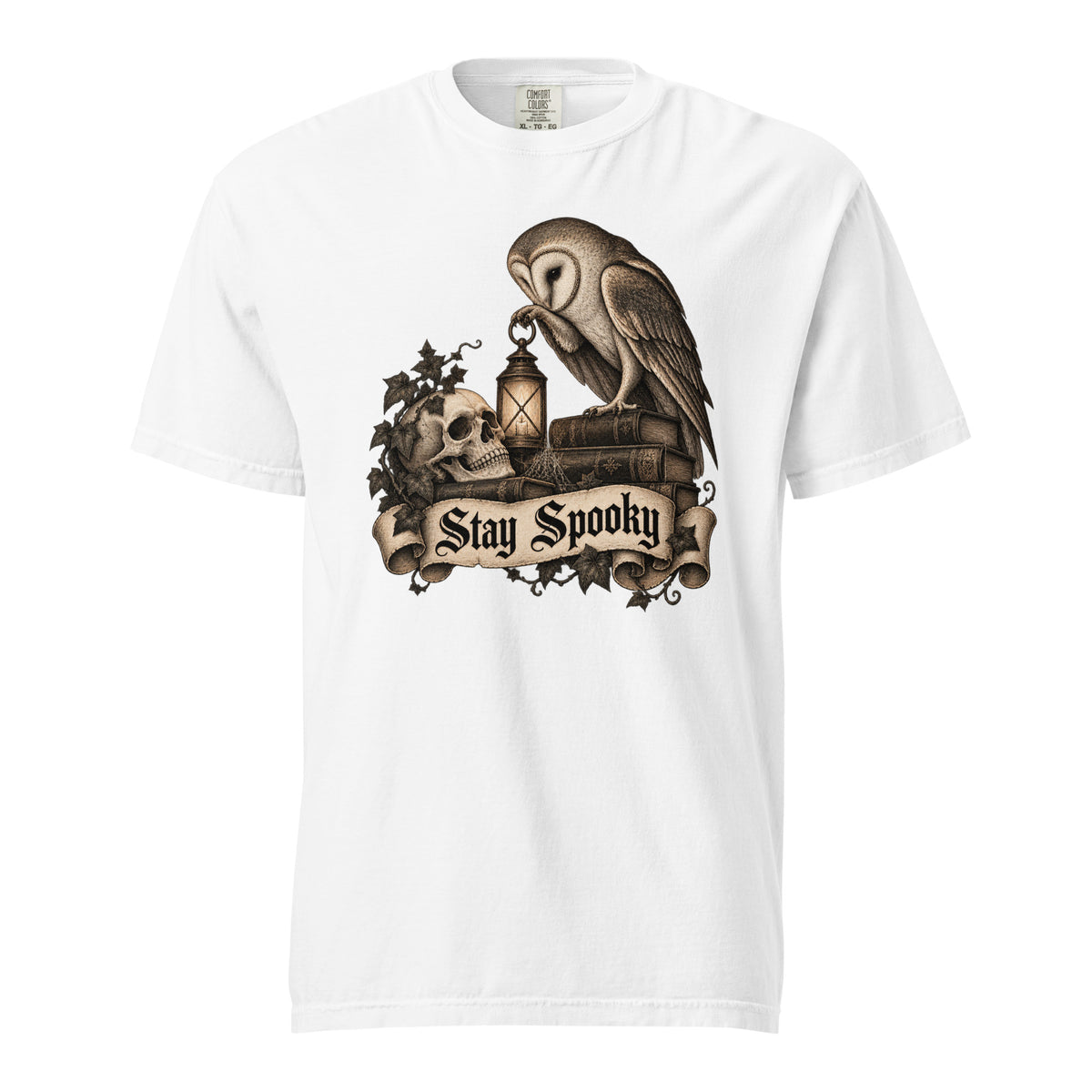 Front view of a white T-shirt featuring an owl, skull and lantern above a scroll reading “Stay Spooky” in gothic lettering.