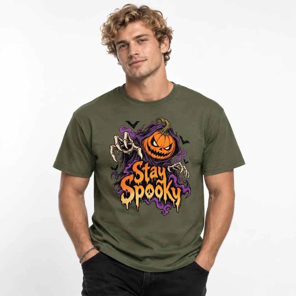 Front model view of a Sage T-shirt with a Stay Spooky graphic featuring an angry pumpkin, skeletal hands, purple smoke, and black bats.