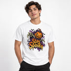 White t shirt featuring A front chest graphic reads “Stay Spooky” in large dripping orange and cream lettering. Above it is an angry orange jack-o’-lantern framed by purple smoky shapes, with reaching skeletal hands and