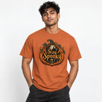 Front view of a model wearing a Yam T-shirt with ornate Stay Spooky artwork featuring a pumpkin, skull, and haunted castle.