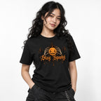 Front view of a Black T-shirt featuring a glowing Jack-O'-Lantern held by Skeleton Hands above ornate “Stay Spooky” lettering.