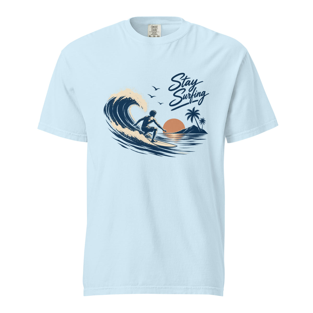 Front view of a Chambray T-shirt featuring a surfer riding a curling wave with palm trees and “Stay Surfing” lettering.