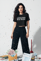 Model wearing the Adulting Is A Scam black crop top with black trousers in a studio scene